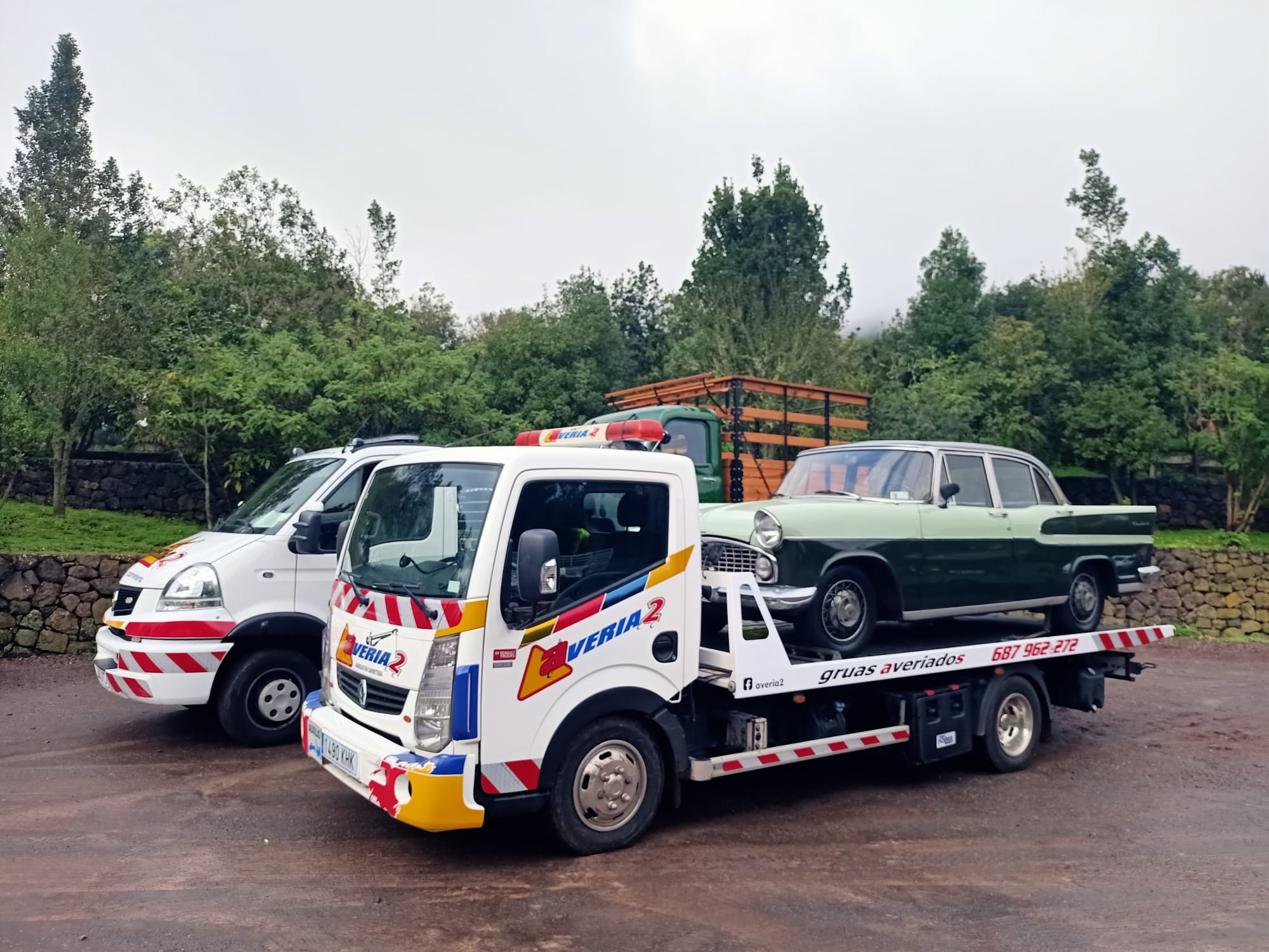 Grúa transportando una berlina clásica verde de colección