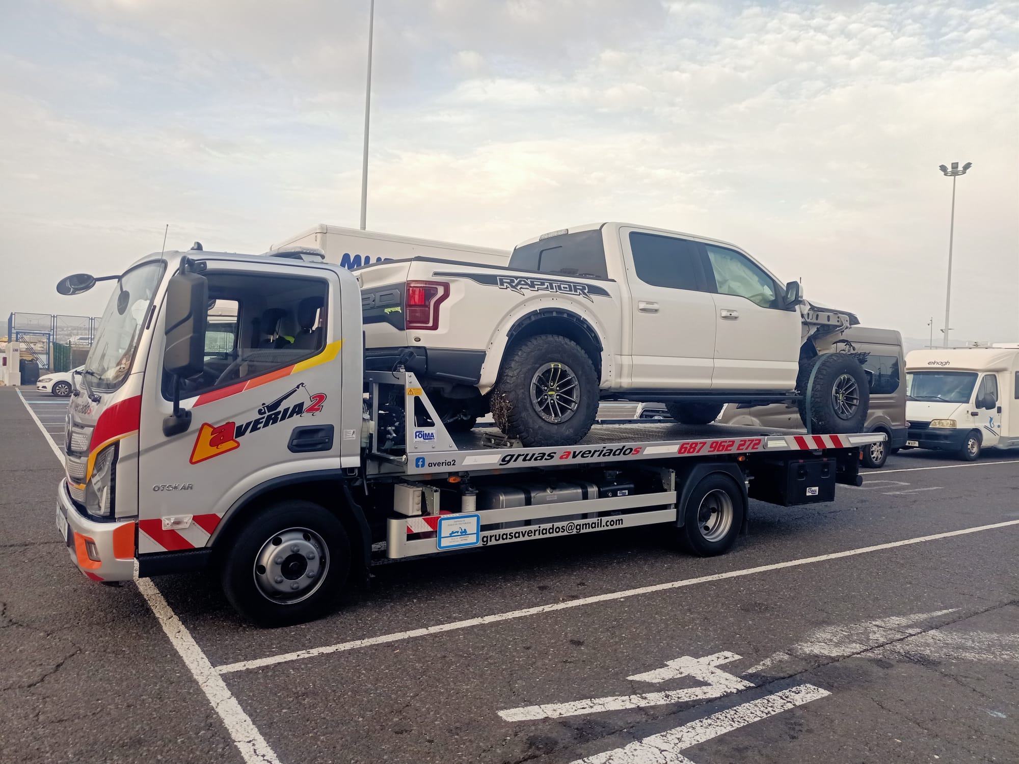 Grúa de Averiados transportando una pickup Ford Raptor