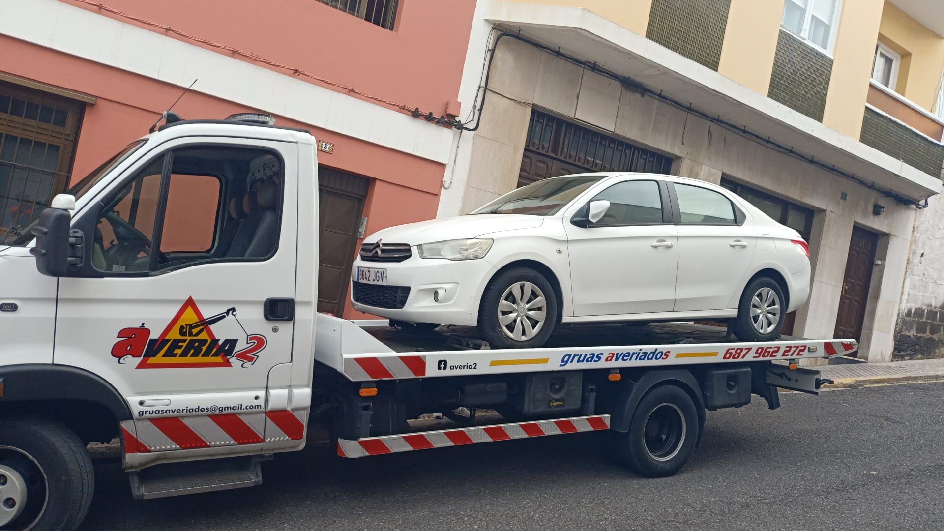 Grúa de Averiados cargando un turismo Citroën en una calle del casco urbano